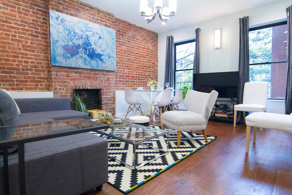 Spacious living room includes large flat screen TV, comfy sofabed, and kitchen table.