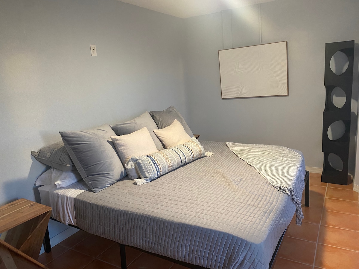Una de las 4 habitaciones king. Este dormitorio está en el primer piso y no requiere escalones. Un baño separado con ducha a ras del suelo está justo fuera de este dormitorio. Este dormitorio tiene una nueva unidad de aire acondicionado independiente recientemente instalada y ventilador de techo. 