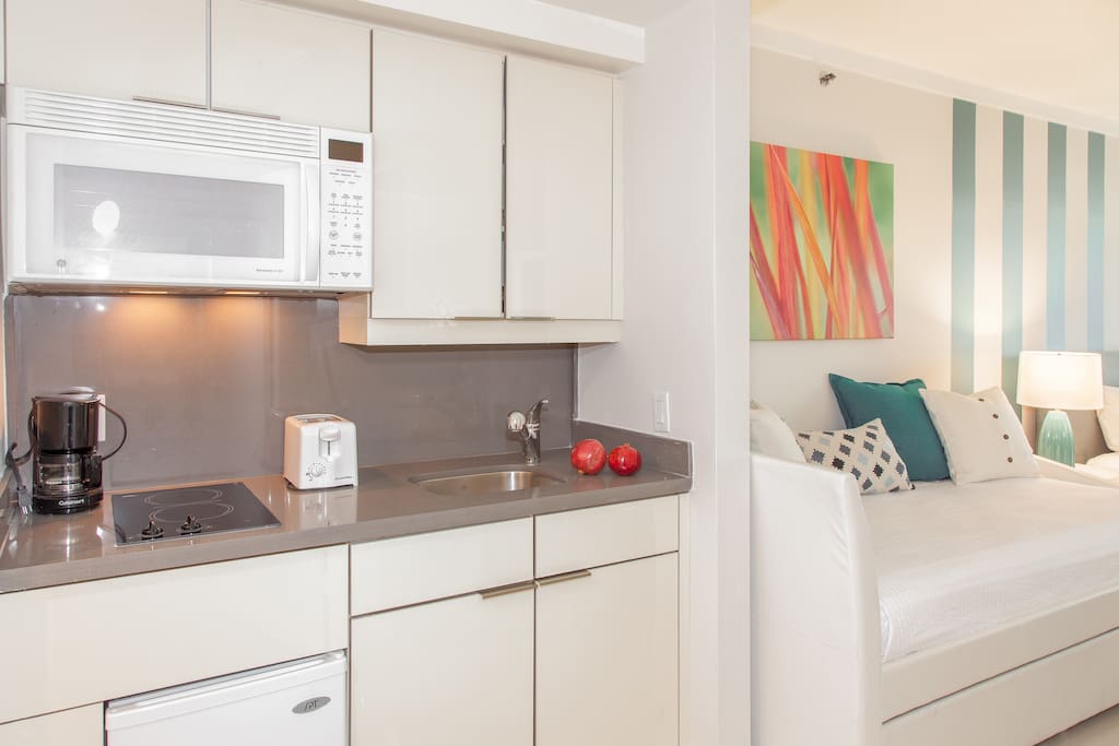 Remodelled kitchenette with quartz countertops and glass ceramic cook top.