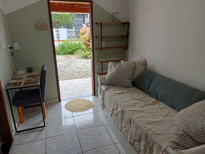 Salla e hyrjes me divan krevat tek, krevat ndihmës, hapësirë për zyra në shtëpi dhe raft këpucësh