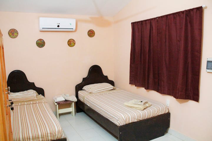 Მეორე საძინებელი. ორი ტყუპი საწოლი, პატარა გარდერობი, კონდიციონერი და ჭერის ვენტილატორი. Მეორე ოთახი. ორი პატარა საწოლი, ტანსაცმლის ავეჯი, A/C და ჭერის ვენტილატორი.