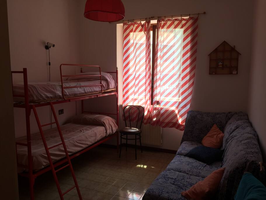 Cameretta con letto a castello e divanetto ad angolo.