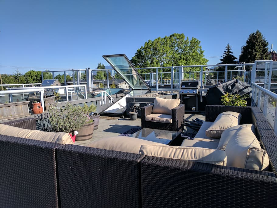 Rooftop patio with large sectional, shade umbrella, heater, BBQ, and bistro table for two