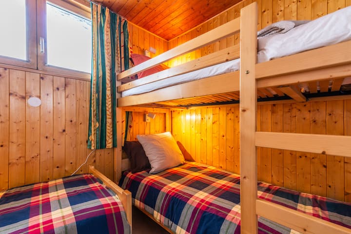 Bedroom with three beds and individual reading lights on all beds.