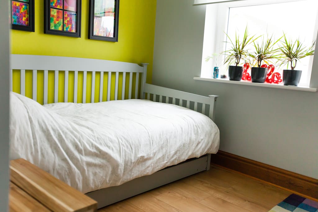 Single bedroom with comfortable single day bed, wooden floors and lots of natural light
