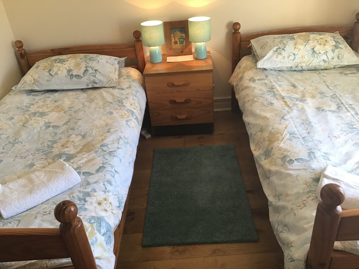 Dvokrevetna soba ima ormar i skromnu komodu.