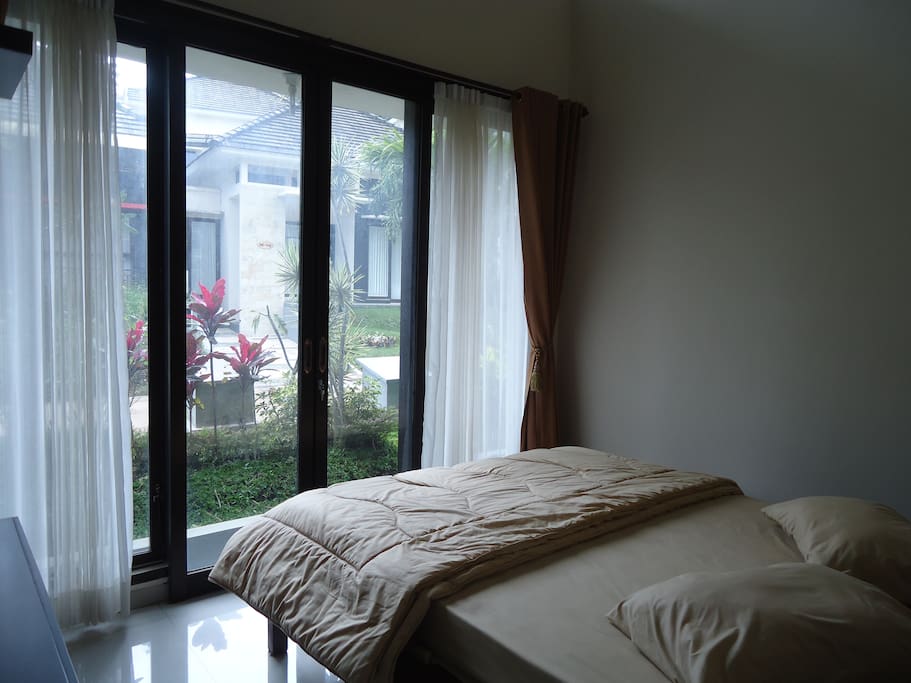 Dari kamar tidur 1, Anda bisa menikmati suasana luar melalui pintu kaca
