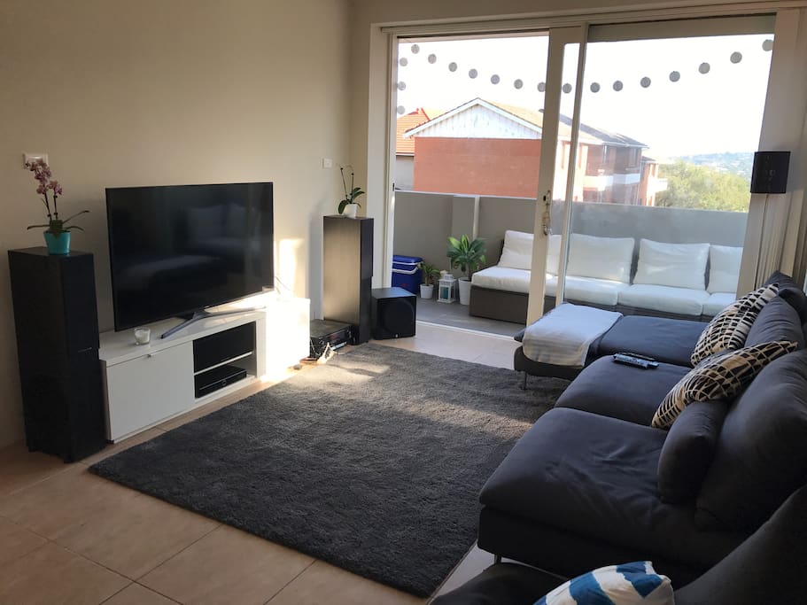 Spacious living area with surround sound system and Foxtel.