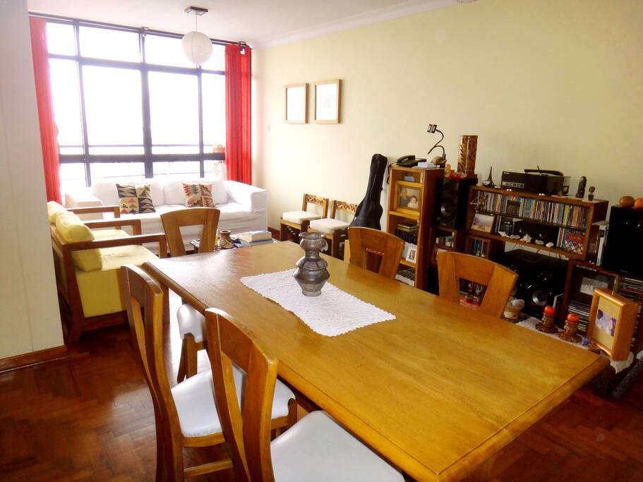 Comedor de madera para 6 personas. Equipo de sonido y stand de libros para que te relajes leyendo.