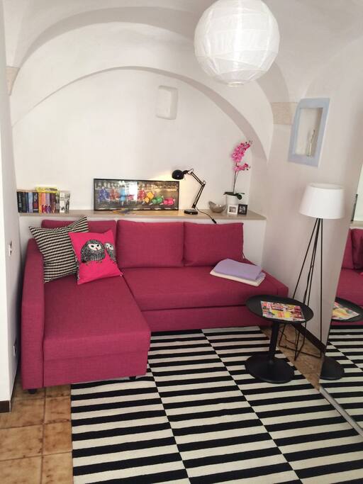 Salotto con divano letto e piccola libreria