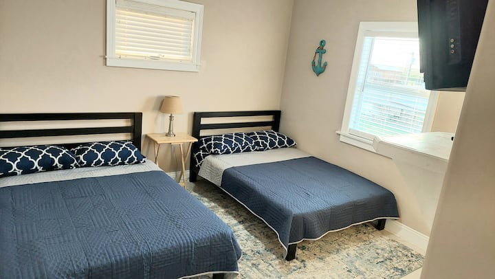 Habitación con 2 camas de tamaño completo y un televisor de 32pulgadas