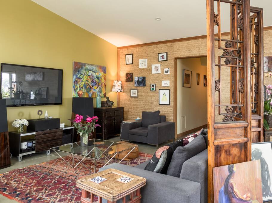 Sofa area with hallway leading to main bedroom and large bathroom