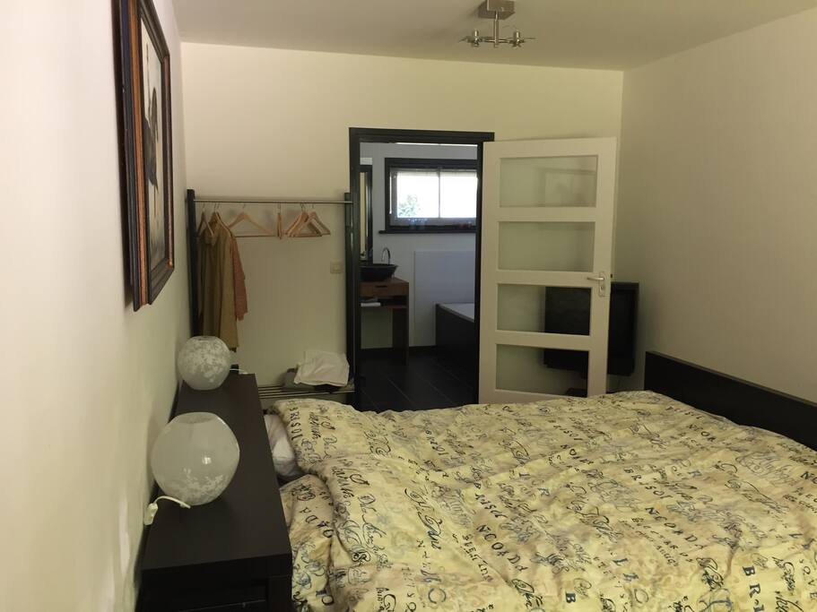 Slaapkamer met badkamer met inloop douche en bad
