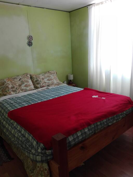 dormitorio principal, con cama Matrimonial rustica, habitación con ventana al exterior.