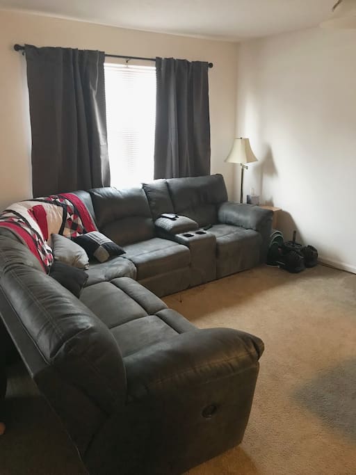 Living space includes section couch that has a recliner on both ends.