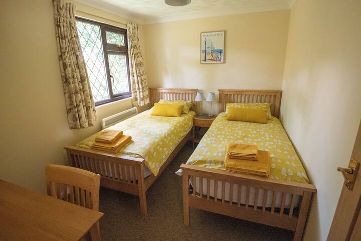 This is the second bedroom equipped with two single beds with premium mattresses. There is a dressing table/desk with mirror and good heating making it a lovely cosy room.