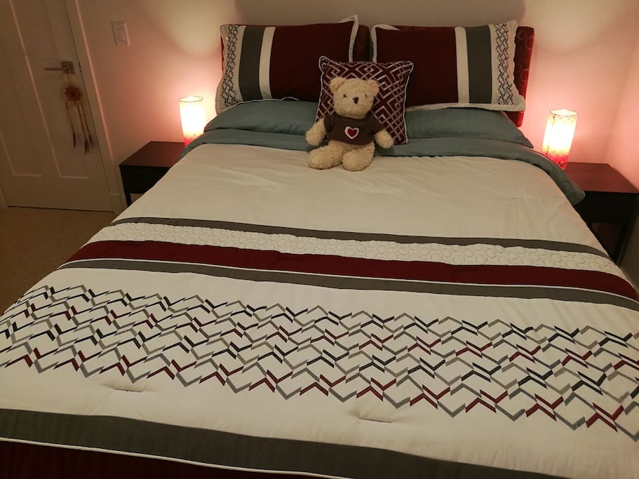 Bedroom A with a queen size bed, two night stands, walking in closet, a chair and a storage stand.