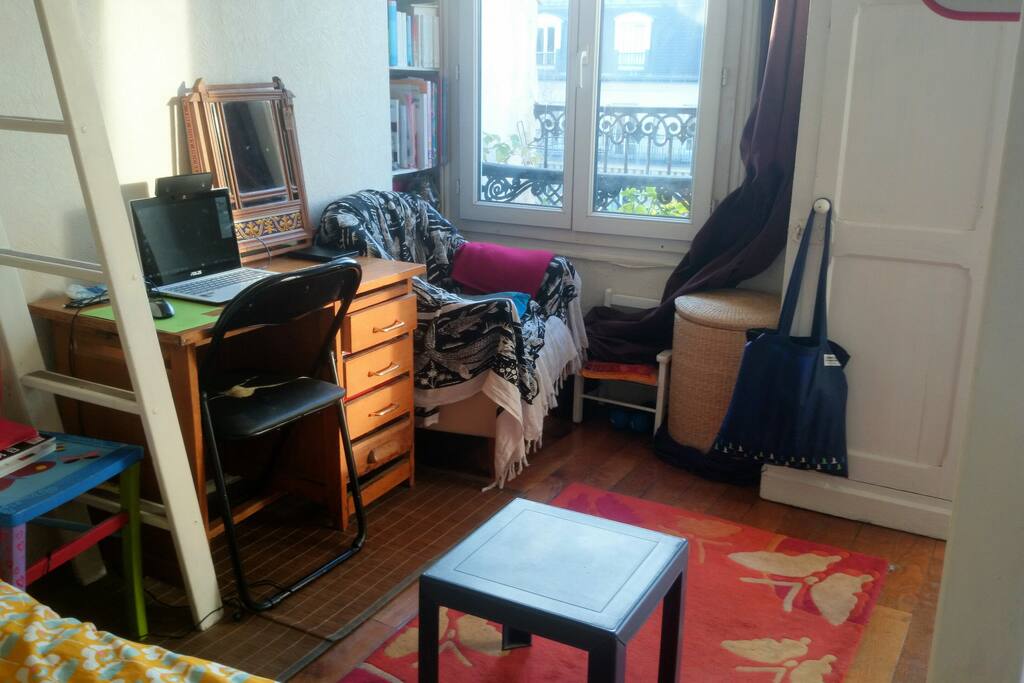 La chambre, un premier fauteuil et son bureau.