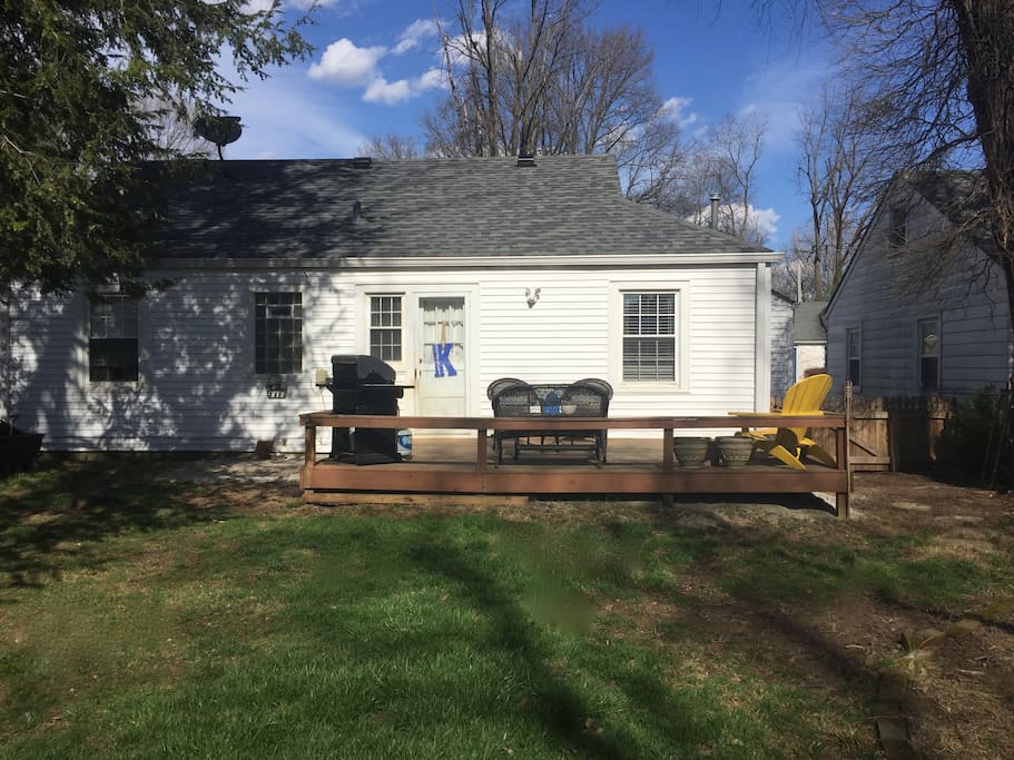 Backyard with deck, grill and patio furniture.