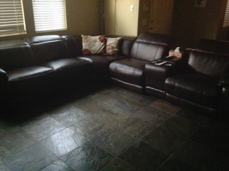 Living room with large sectional and a 65 inch smart flat screen. Nice large open area to relax and catch up on your favorite show.
