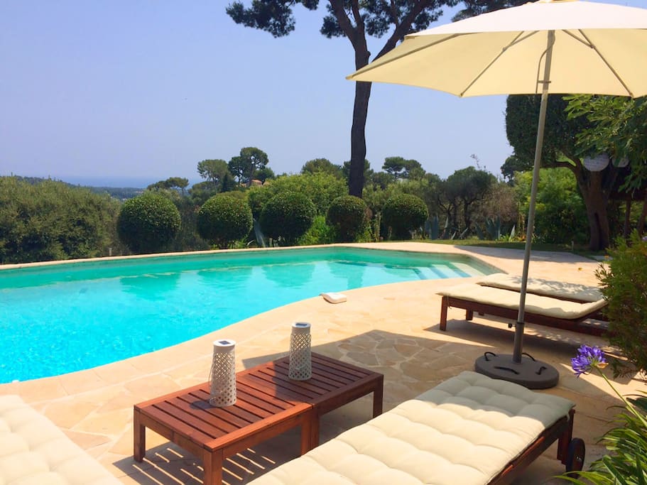 Espace piscine avec bains de soleil et vue mer