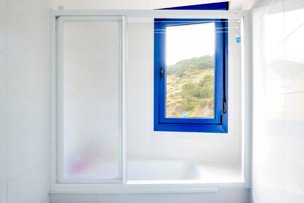 Baño dormitorio ducha con mampara y vistas a la montaña