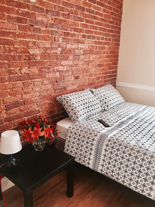 Queen bed with exposed brick