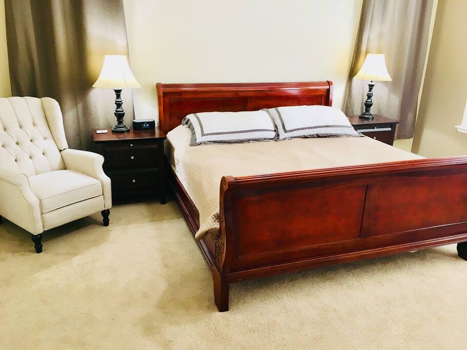 Large master bedroom with king size bed and accent chair