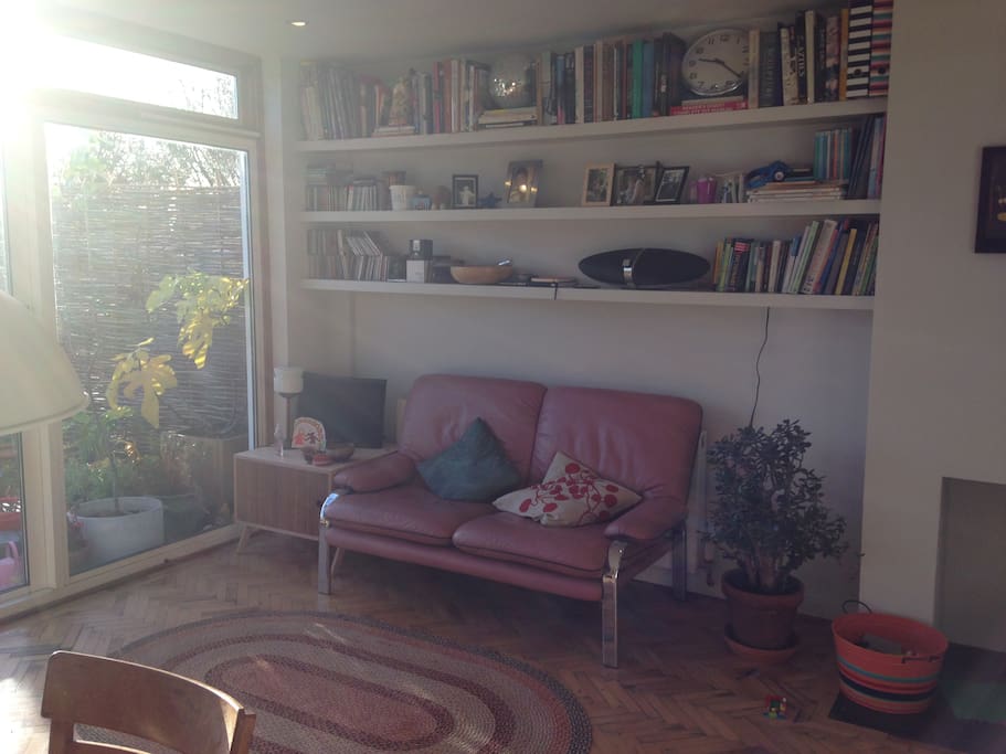 Pink sofa in the kitchen and lots o books.
