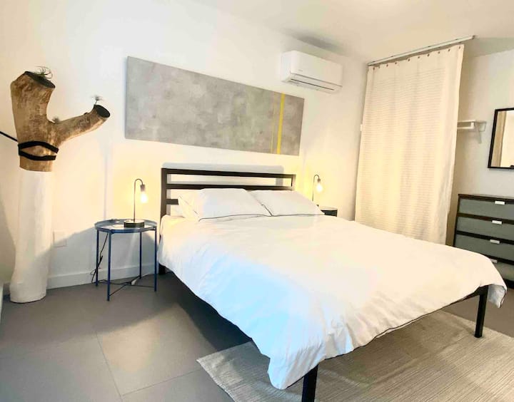 Საძინებელი მეორე, დედოფლის ზომის ლეიბი პლატფორმის საწოლის ჩარჩოზე, კარადა, შუშის კარის გასასვლელები უკანა ეზოში. 