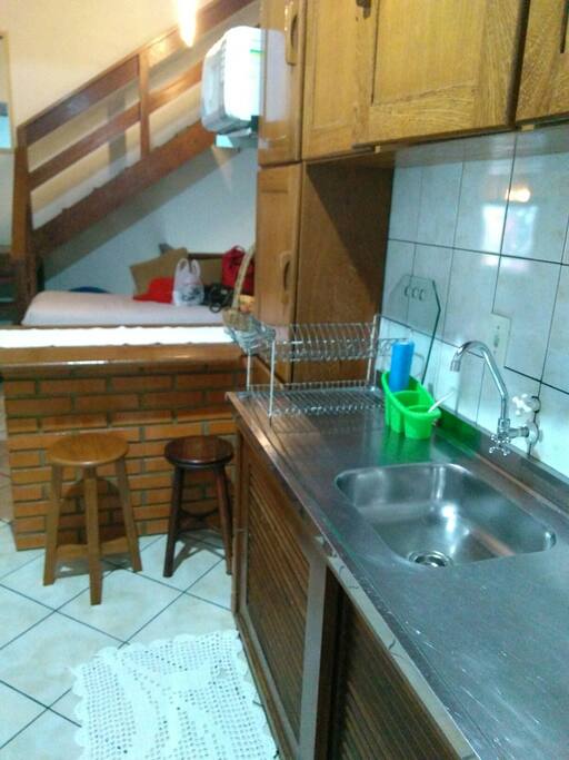 Cozinha com fogão, geladeira, microondas e máquina de lavar.
