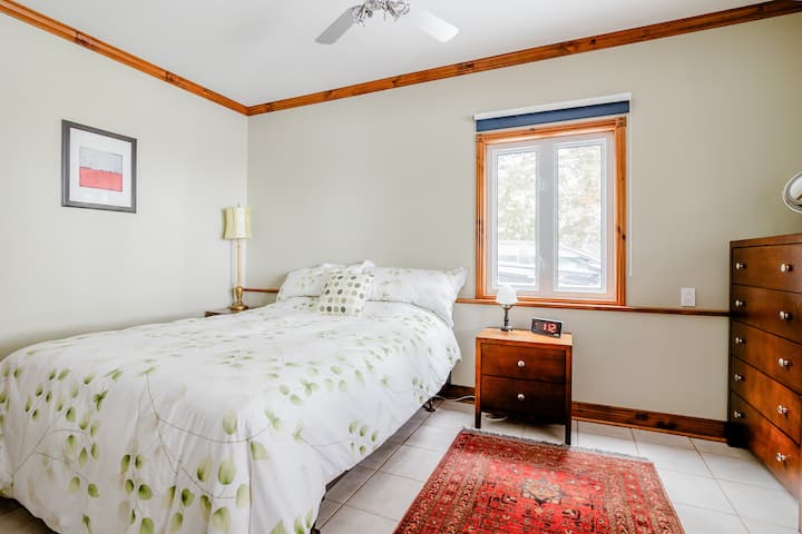 חדר שינה ראשי עם מיטת קווין סייז ונוף לאגם