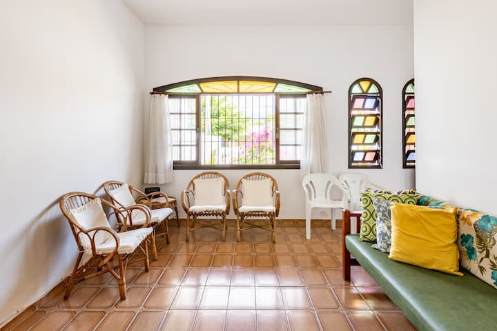 Woonkamer in combinatie met eetkamer. Het heeft twee plafondventilatoren, een flatscreen-tv en een slaapbank.