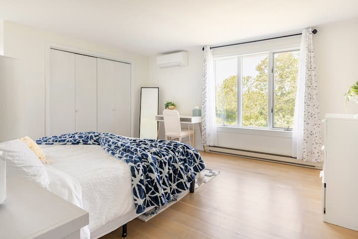 Spavaća soba s bračnim krevetom i puno prirodnog svjetla.