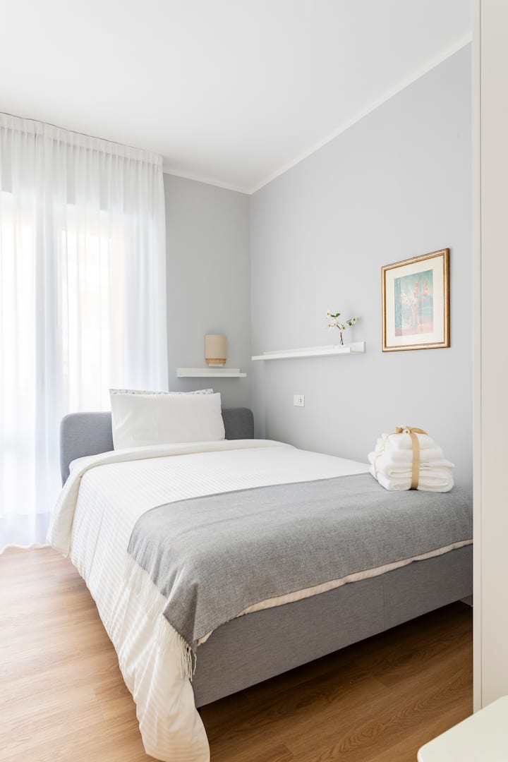 غرفة مشرقة ومريحة مع سرير 150 سم وخزانة ملابس واسعة وإمكانية الوصول المباشر إلى الشرفة. مفروشة بأسلوب بسيط ومريح، مثالية للراحة. مكتمل ببياضات عالية الجودة.