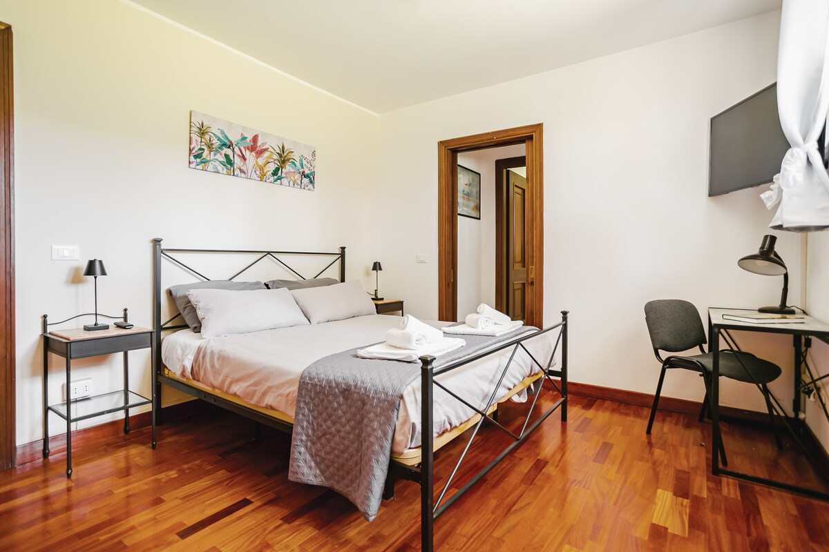 Cama tamaño queen, TV de 40pulgadas y rincón de estudio