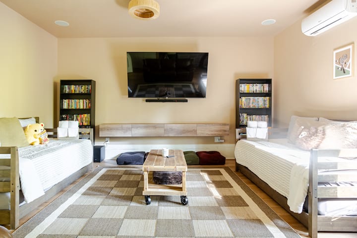 Habitación extra ubicada a través del garaje, perfecta para la noche de películas y juegos. Conecta fácilmente tus propios dispositivos a la placa de pared HDMI para que no tengas que ir detrás del televisor de 75 pulgadas. Abundante cantidad de DVD clásicos, cintas VHS, juegos de mesa y libros.