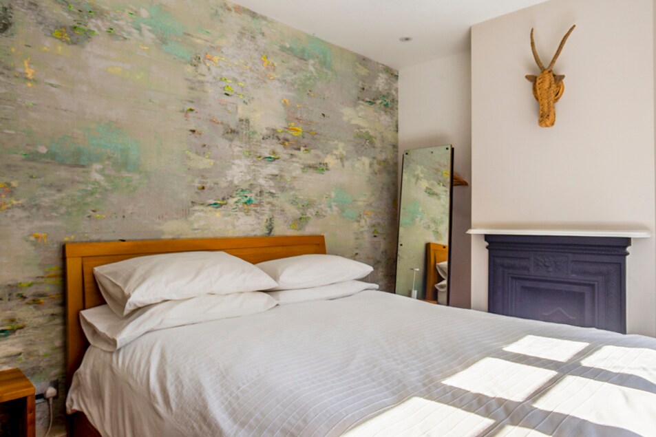 Comfortabel queensize bed voor handgeschilderd behang. Er is opbergruimte achter de spiegel, onder het bed, in een kofferbak en in een kast onder de trap. Welke trap?