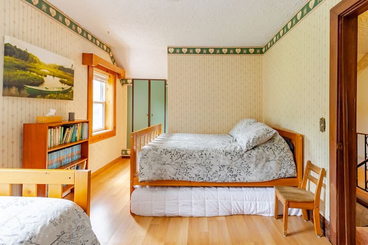 Chambre avec lit double, lit simple et salle de bain attenante.  