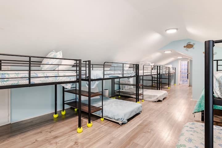 Detta rymliga loftliknande rum med våningssäng har 1 queensize-säng och 10 enkelsängar som är idealiska för stora familjer eller grupper. Mjuka kustfärger, havssköldpaddsdekor och en öppen planlösning skapar ett roligt, barnvänligt utrymme för alla att varva ner och sova bekvämt.