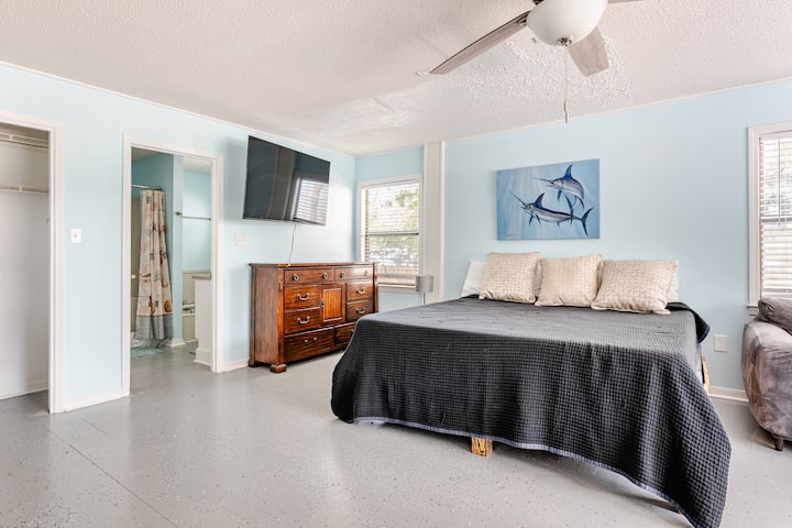 [Main Level Bedroom] Detta rymliga sovrum har en bekväm king size-säng, en utdragbar soffa, en platt-TV och ett eget badrum – perfekt för både avkoppling och bekvämlighet.