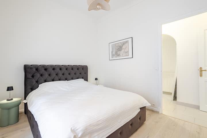 Dormitorio moderno y cómodo con una cama tamaño queen y sábanas suaves. 