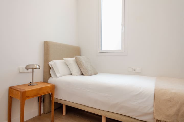 Mulighed 2: Hyggeligt enkeltværelse med en seng på 90 x 190 cm, motoriserede persienner til at styre lys og privatliv og et arbejdsområde med skrivebord og stol, ideel til at arbejde eller studere i et roligt og behageligt miljø.