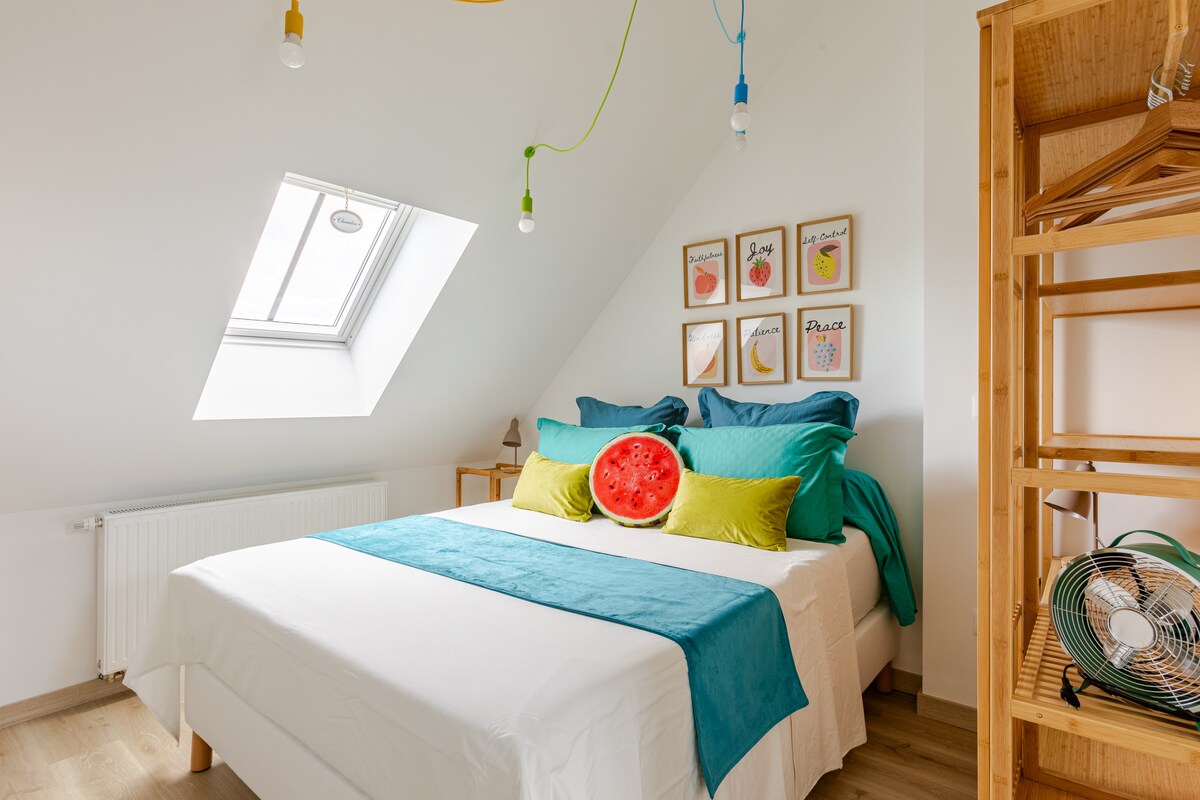 Duik in de slaapkamer op de fruitzolder, een gezellige ruimte waar een queensize bed op je wacht onder de sterrenhemel. Geniet van een fruitige en gastronomische sfeer, perfect voor een fris verblijf, vol pep's in Colmar.