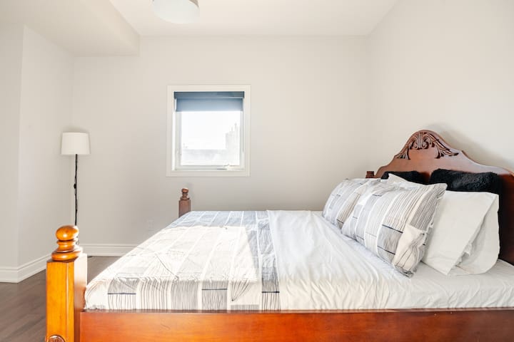 この静かな寝室には、Sleep Countryのマットレスを備えた豪華なキングサイズベッドと、エレガンスと魅力をプラスする印象的なフルウォールアートワークが備わっています。自然光が溢れるお部屋は、リラクゼーションと安らかな眠りに最適な落ち着いた魅力的な隠れ家的空間です。