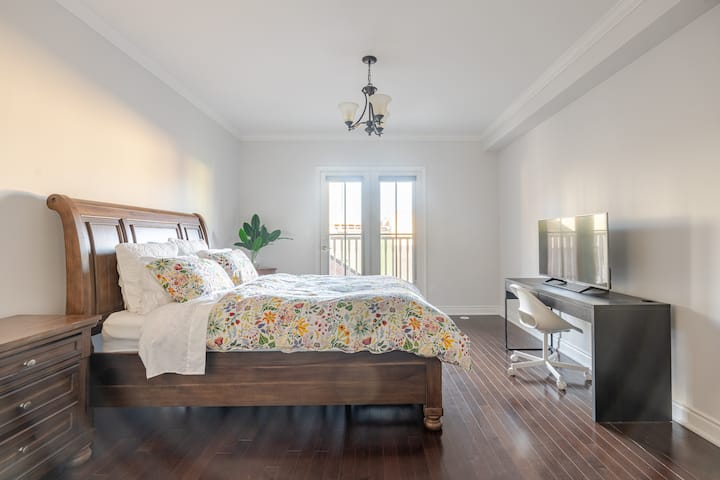 3階全体を占める650平方フィートのエレガントなマスターベッドルームで、居心地の良いクイーンベッド、花柄の寝具、クラシックな木製家具が特徴です。フランス式のドアを開けると、パリスタイルのバルコニーがあります。テレビ、シャンデリア、機能的なワークデスクが含まれています。