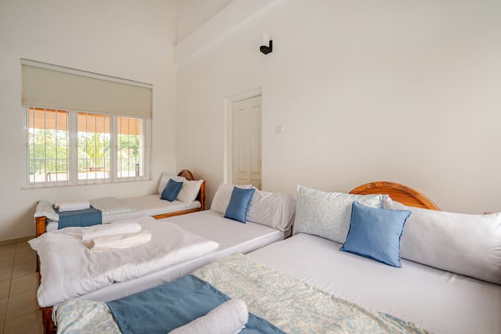 Triple Sky Loft- A spacious room with multiple beds, a two-way balcony offering stunning views, and a relaxing ambiance perfect for families or groups seeking comfort and tranquility.