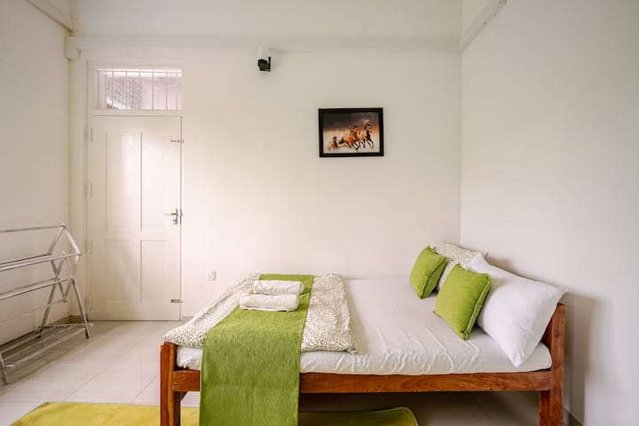 Garden Grove – Cosy green-themed room with elegant flowery wall lights, shared balcony with Bedroom 1, overlooking a peaceful garden. The balcony is perfect for a private dinner under the garden umbrella, with a stunning view of the starry night sky.