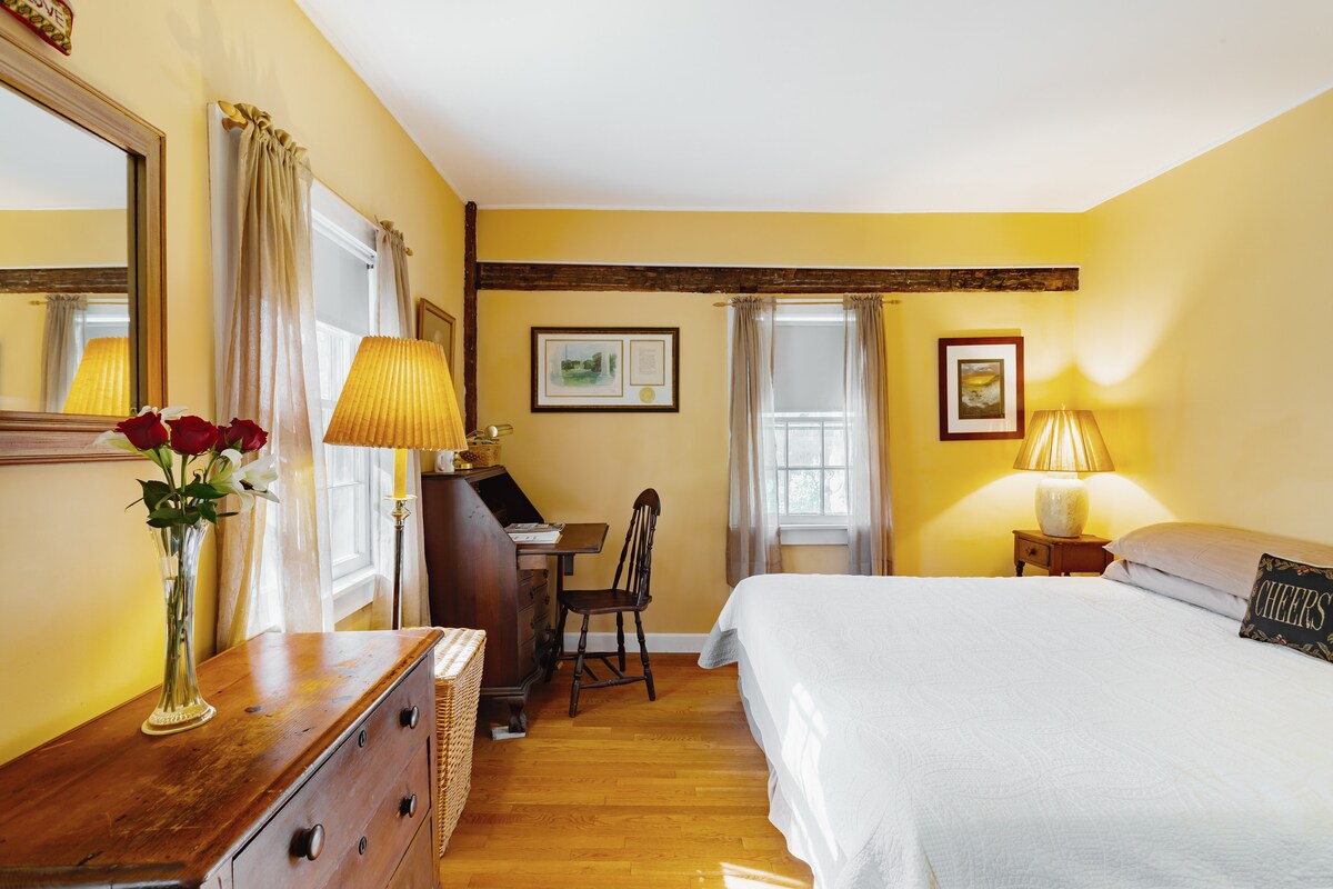 חדר שינה גדול עם מיטת קינג סייז ושולחן כתיבה.