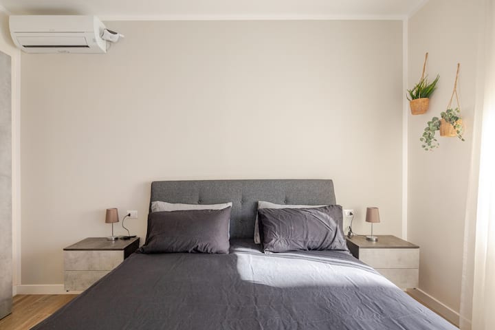 Тази просторна стая с модерно и минимално двойно легло, с голям прозорец и врата на прозореца, която води директно към самостоятелния балкон.
Климатик - 50 - инчов СМАРТ телевизор с включен абонамент за Netflix